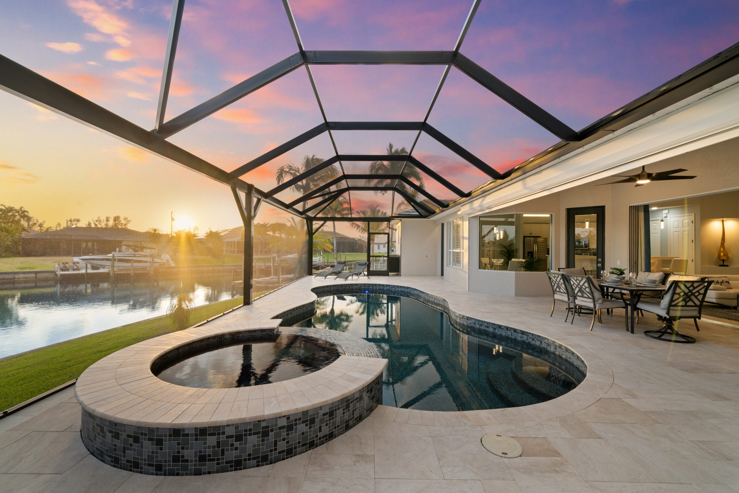 Privater Poolbereich einer stilvollen Ferienvilla in Cape Coral mit überdachter Terrasse bei Sonnenuntergang