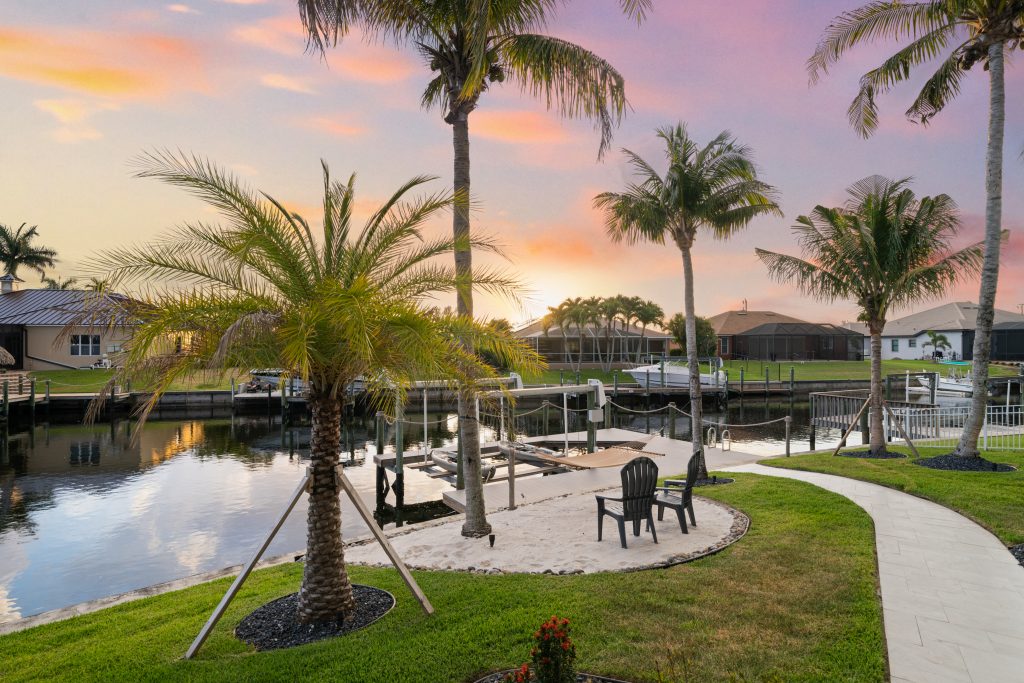 Privates Ferienhaus in Cape Coral mit Palmen, Kanalblick und eigenem Steg bei Sonnenuntergang
